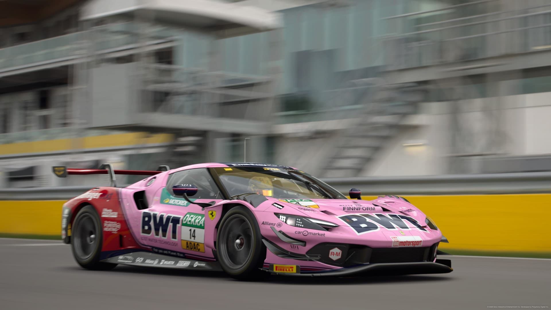 Pink GT race car passing the pit wall at speed